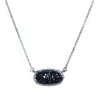 Oval druzy pendant necklace with sparkling black stone on silver chain.