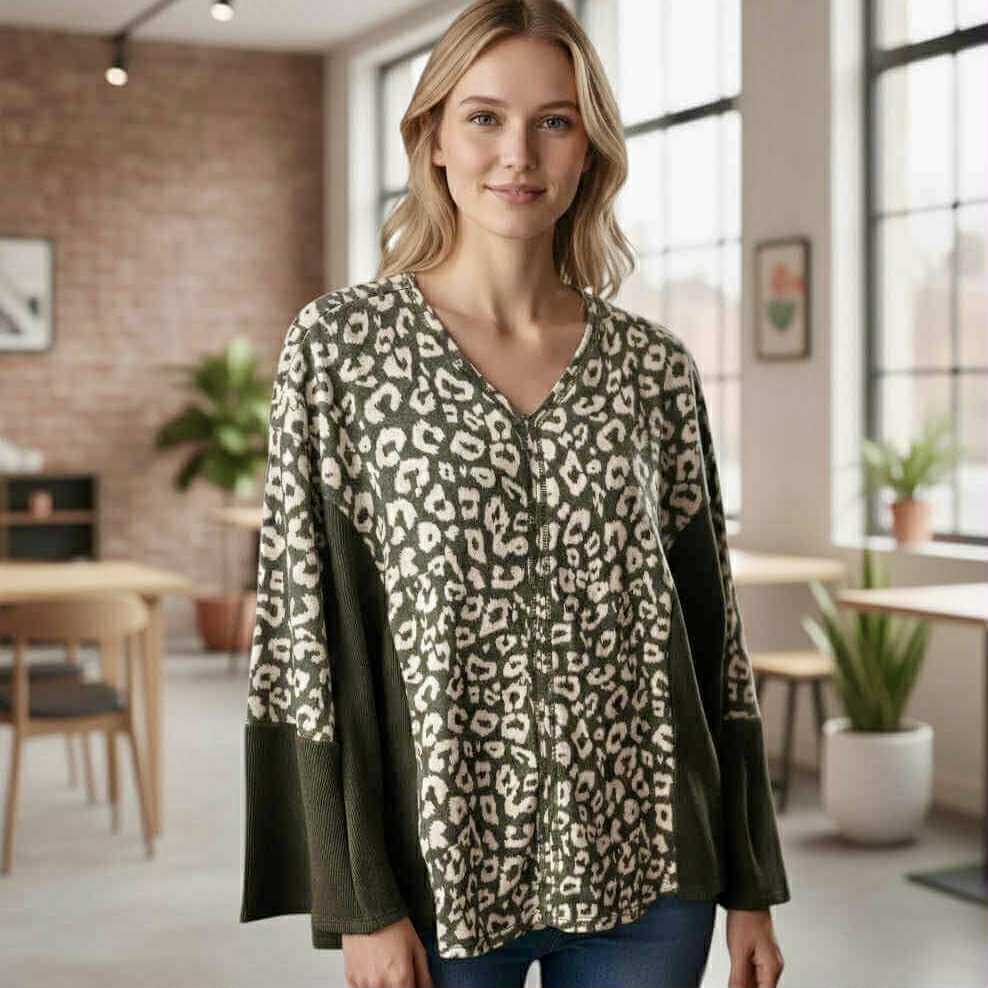 Model wearing UNTAMED SPIRIT TOP (Chai Latte) featuring leopard print and ribbed accents in a cozy indoor setting.