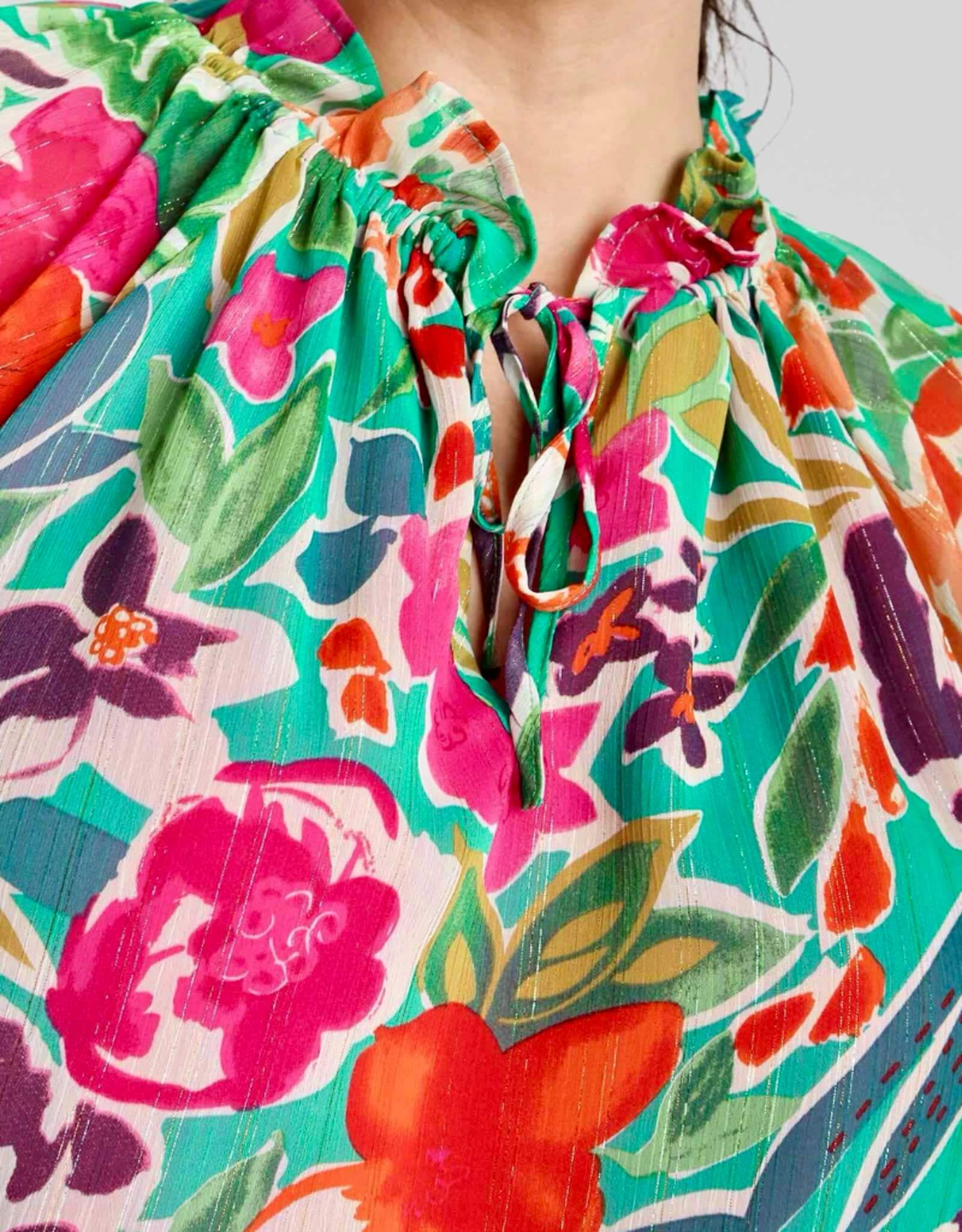 Close-up of The Perfect Blend Top featuring vibrant floral patterns and fuchsia accents on a curvy model.