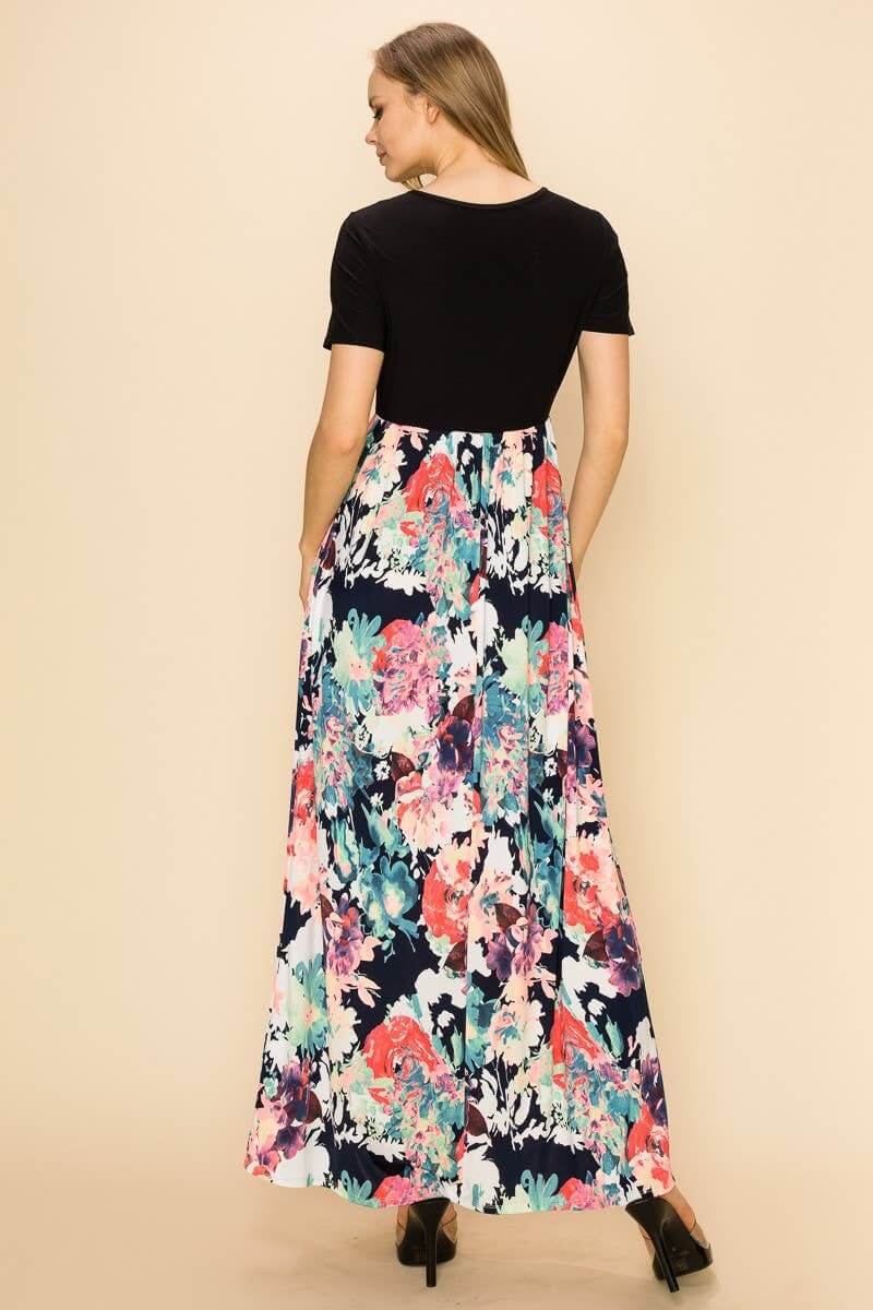Raven Radiance Maxi Dress showcasing black bodice and vibrant floral skirt from the back, perfect for modern style.