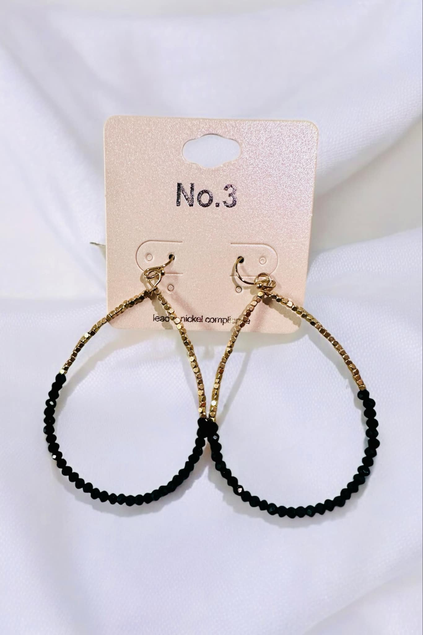 Sharla Beaded Earrings by No. 3 Jewelry featuring black beads and gold accents on display.