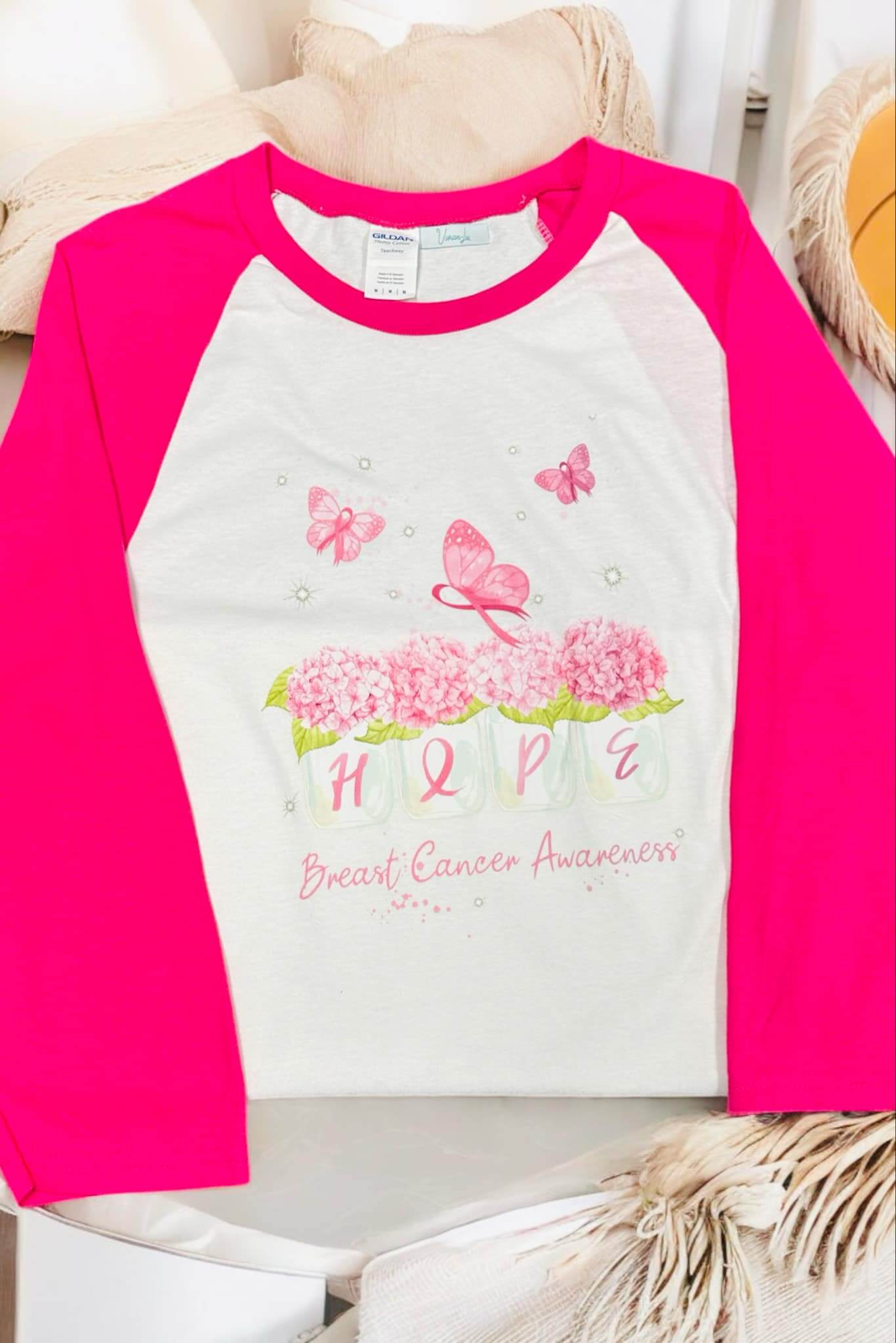 Breast Cancer Awareness T-Shirt with pink raglan sleeves and floral design featuring the word 'HOPE'.