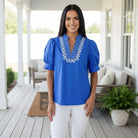 Model wearing BRIGHT FUTURE TOP - Entro in blue with embroidered V-neck collar, showcasing a stylish and comfortable look.