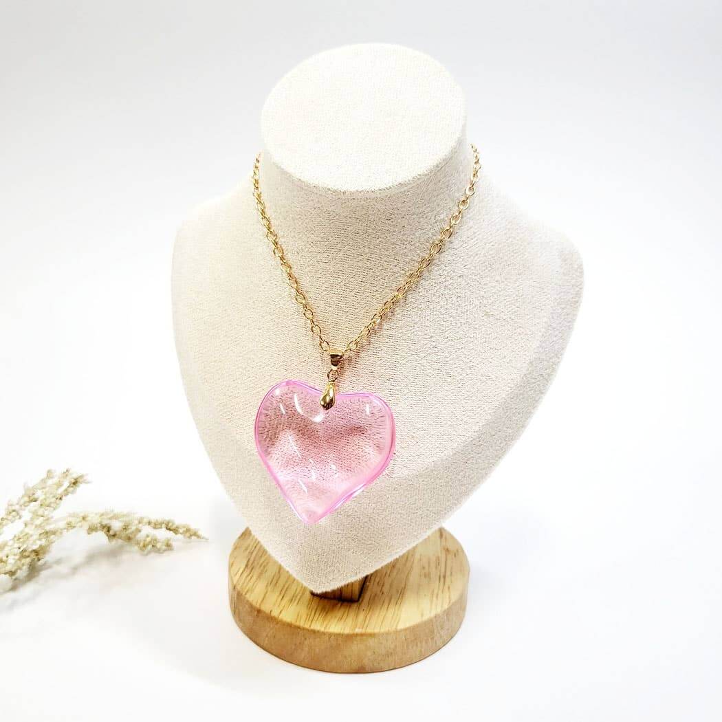 Pink heart-shaped pendant necklace on display, perfect for Valentine's Day gift packs.