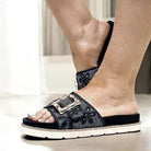 Black slide sandals by Corkys featuring oversized buckle and eyelet detail, perfect for summer comfort and style.