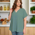 Plus size woman wearing the Air Kiss Top by Zenana in ash jade, featuring a V-neckline and relaxed fit.
