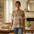 Model wearing SOFT STRUCTURE TOP - She + Sky with floral pattern and subtle puff sleeves in a cozy setting.