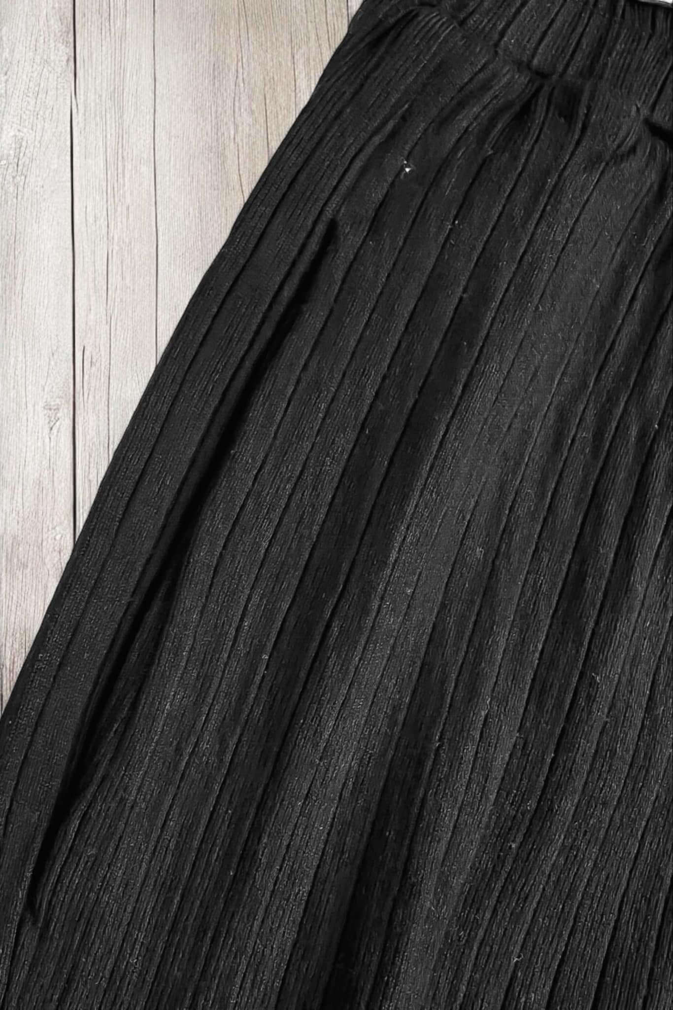 Close-up of black ribbed fabric of Easy Living pants by Sugarlips, showcasing the pleated texture and elastic waistband.