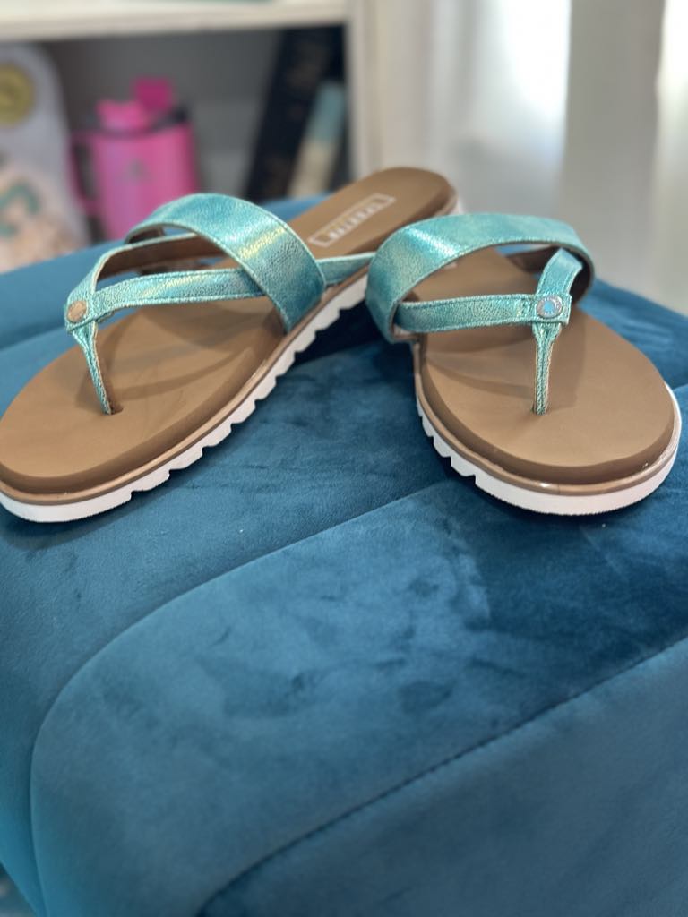 YELLOW BOX - SHAYNE turquoise sandals with silver accents on a blue ottoman for sporty summer style.