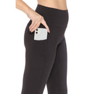 Woman wearing MOVE YOURSELF LEGGINGS in black with phone in side pocket, highlighting the comfort and practicality for active wear.