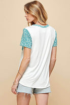 Back view of women's animal print contrast round neck t-shirt with leopard sleeves and white body.