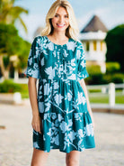 GLORIOUS DAY Dress - Jodifl by JODIFL $36.00 Enhance your style with the stunning teal green dress adorned with a beautiful baby blue floral print. This dress features a unique button-up design with pin tuck fold details, short sleeves, buttoned band cuff