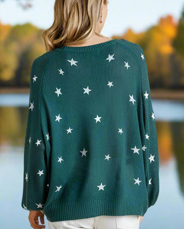 Teal green Umgee Seeing Stars sweater with white star pattern, worn outdoors in a scenic autumn landscape.