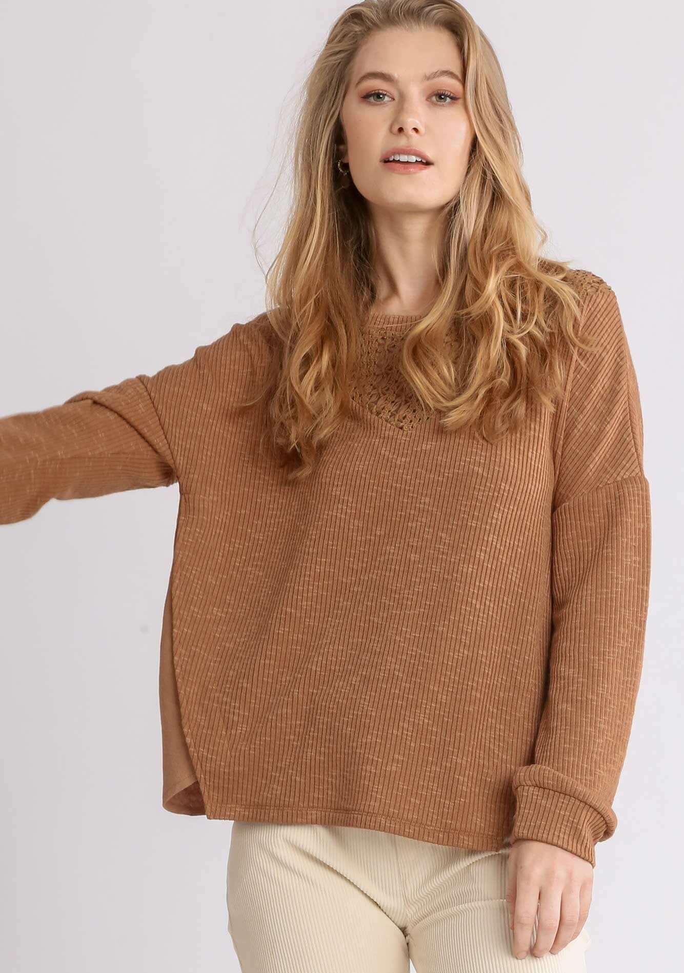 Woman wearing UMGEE cinnamon top with crochet yoke and long sleeves, showcasing loose fit and comfort.