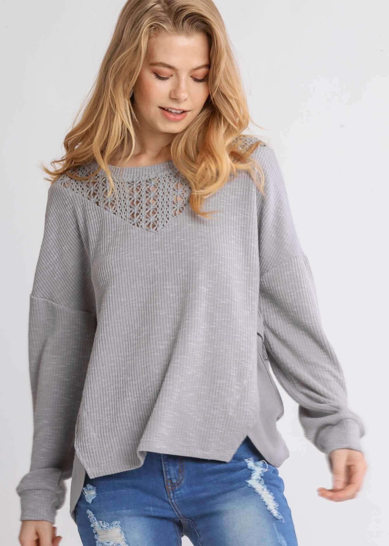 Woman wearing UMGEE Free and Easy Top in Cool Gray with crochet yoke and long sleeves, styled with blue jeans.