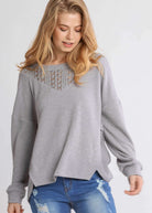 Woman wearing UMGEE Free and Easy Top in Cool Gray with crochet yoke and long sleeves, styled with blue jeans.