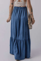 FLY WITH ME maxi skirt in denim, featuring a flowing design and tiered hem, perfect for stylish summer outfits.