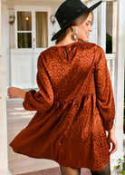 Woman wearing BRONZE BEAUTY DRESS with animal jacquard print and button closure keyhole back, posing on a porch.