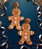 Festive gingerbread couple earrings made of polymer clay, featuring pink hearts and a classic design on a sparkling background.