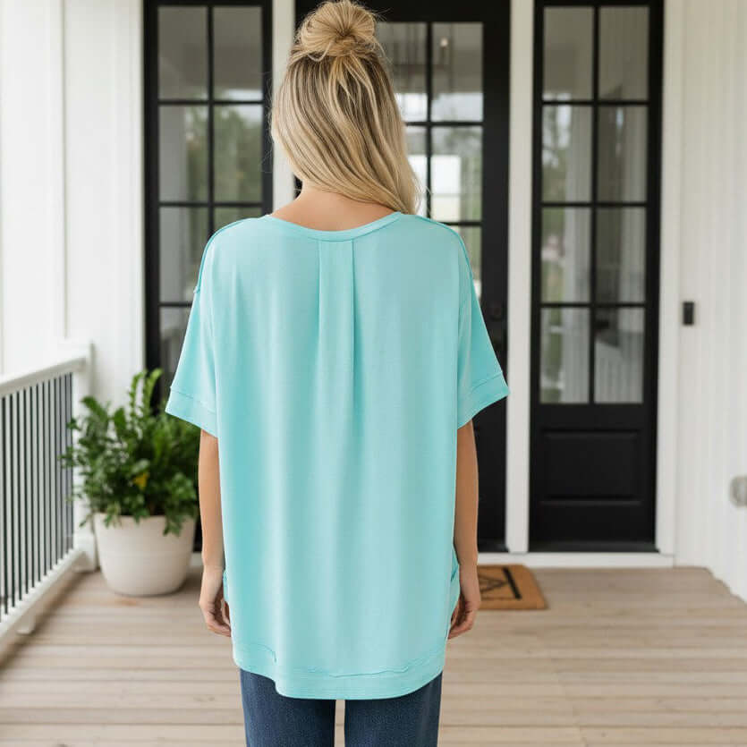 Back view of a woman wearing the DAILY GO-TO TOP - Andree' in a relaxed fit and light blue color.