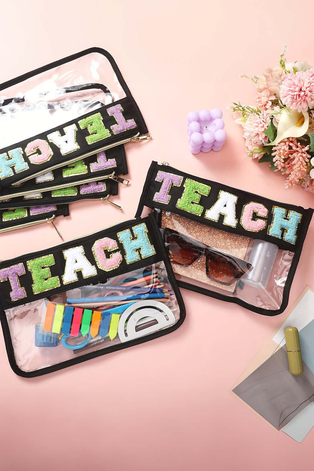 Colorful In My Teacher Era clear pouches displaying supplies, featuring bold TEACH embroidery on a sleek black background.