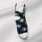 Plush winter snowflake sherpa socks in black and white, perfect for staying cozy and warm during the winter season.