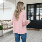 Woman wearing SIMPLY ENCHANTED TOP (pink) with lace mesh sleeves on a porch.