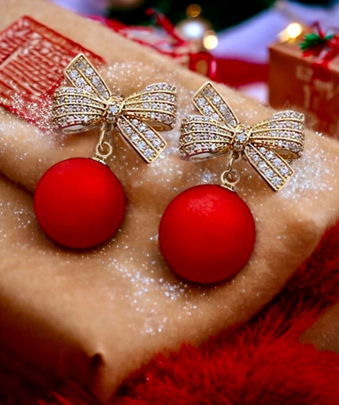 Stunning festive earrings featuring a gold bow and red Christmas ball, perfect for holiday celebrations and adding cheer to any outfit.