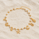 Seaside Glam Charm Necklace with pearls and seashells on sandy background, capturing coastal elegance.