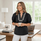 Structured Grace Top in black with puff sleeves and embroidered detail, perfect for versatile occasions.