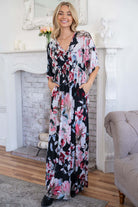 Floral maxi dress with pockets and flowy, stretchy fabric in a cozy living room setting.