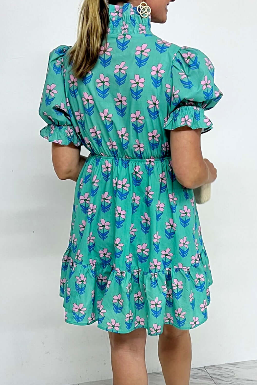 Ruffled Romance Dress showcased with aqua floral print and frilled neckline, perfect for a feminine spring look.