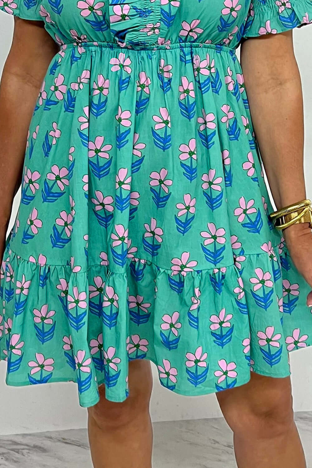 Aqua floral print mini dress with ruffled hem and frilled neckline, perfect for springtime charm.