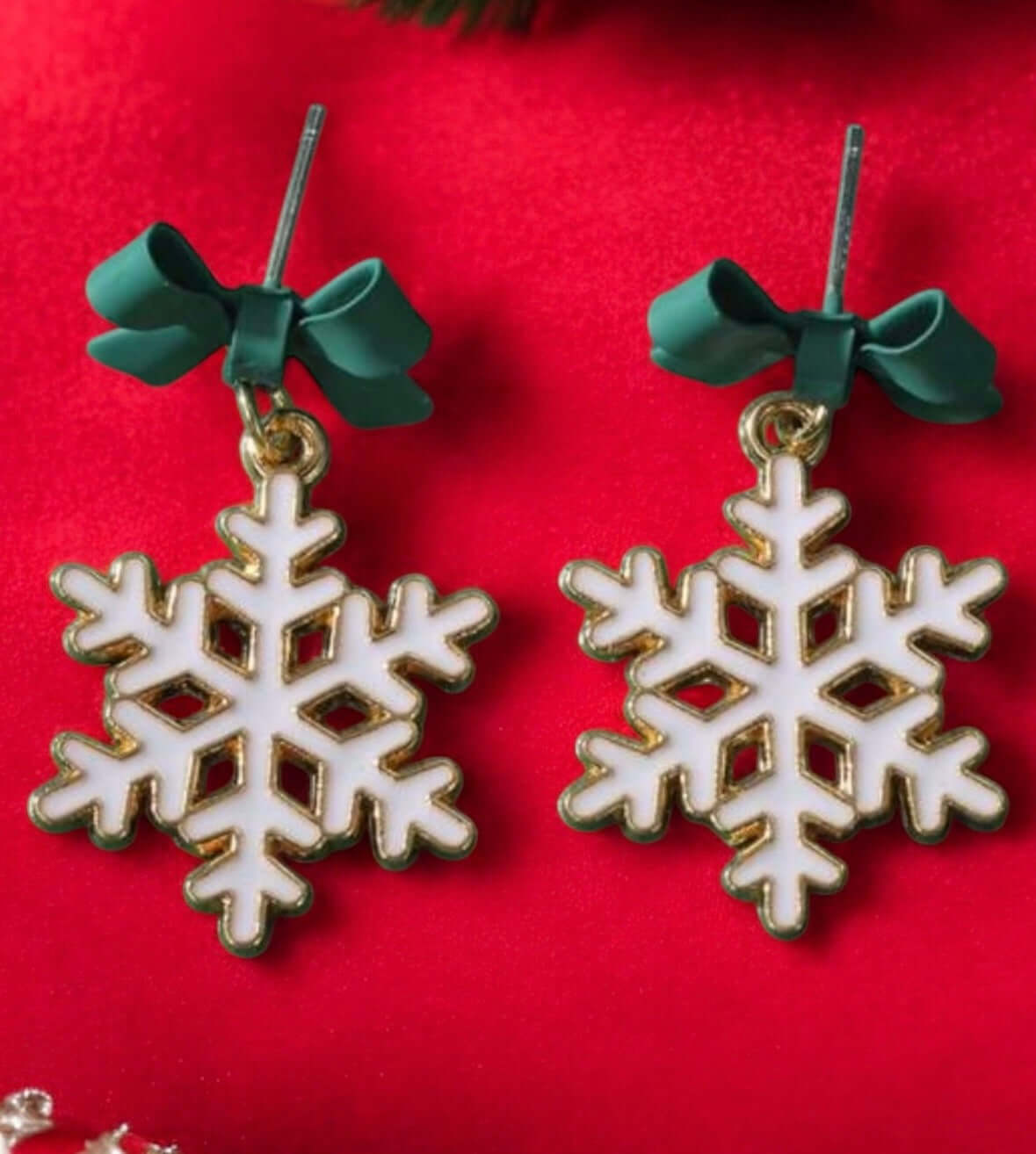 Winter Wonderland Snowflake Earrings with green bows on white snowflake studs, perfect for the holiday season.