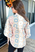 Back view of a woman wearing the Painted Horizon Top, showcasing its colorful geometric pattern and relaxed style.