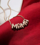 Bubbly Mama Necklace in rose gold tone on red fabric, featuring a bold 'MAMA' charm.