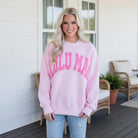 LULU MAC Pink with Taffy Puff Logo Crew (Copy) worn by a smiling woman on a porch in a relaxed setting.