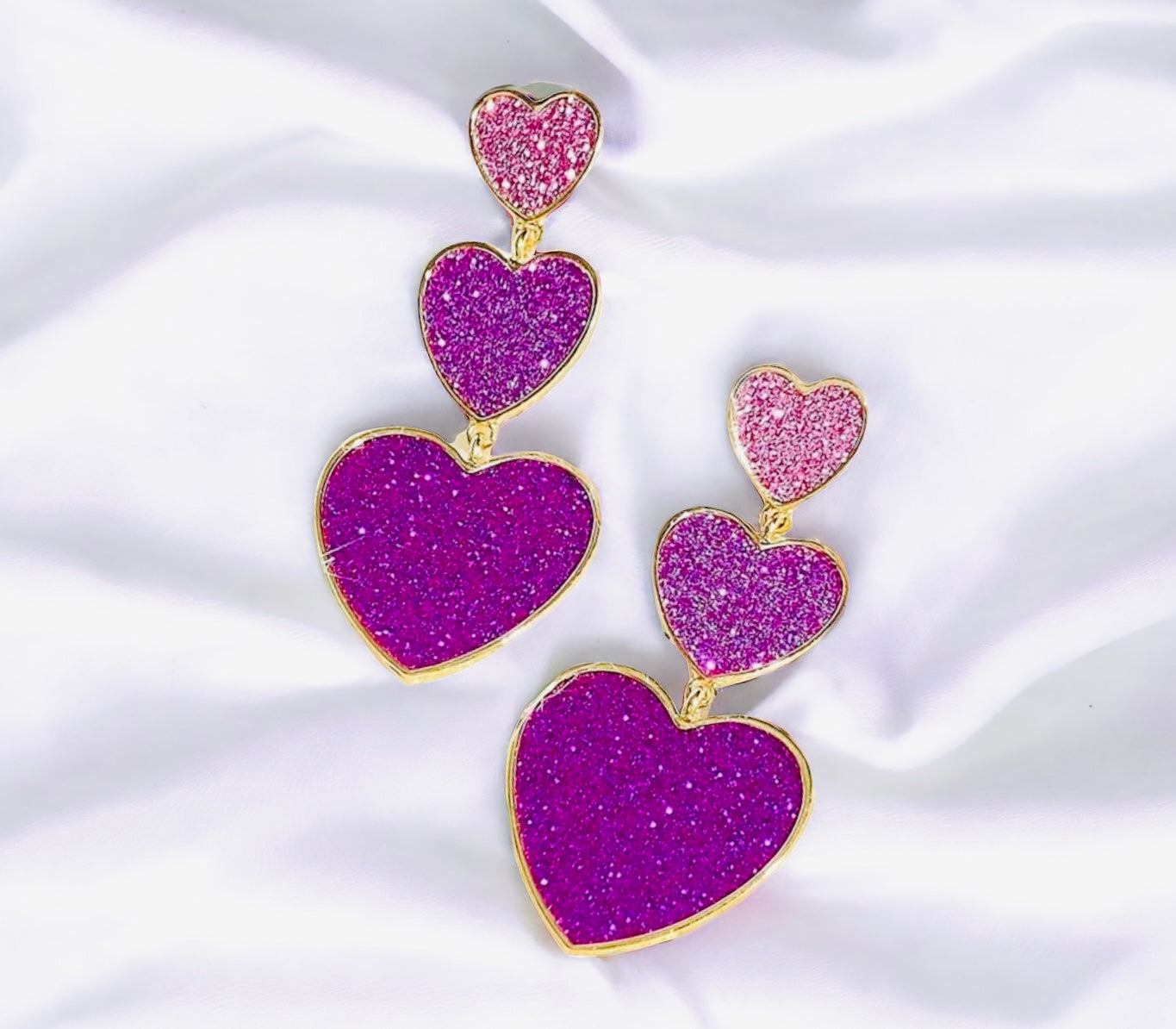 Sparkling purple heart earrings in gold tones, perfect for adding a touch of glamour and love to your outfit.