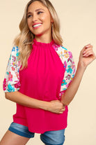 Bright pink PETAL PASSION TOP with floral sleeves, perfect for a chic casual look.