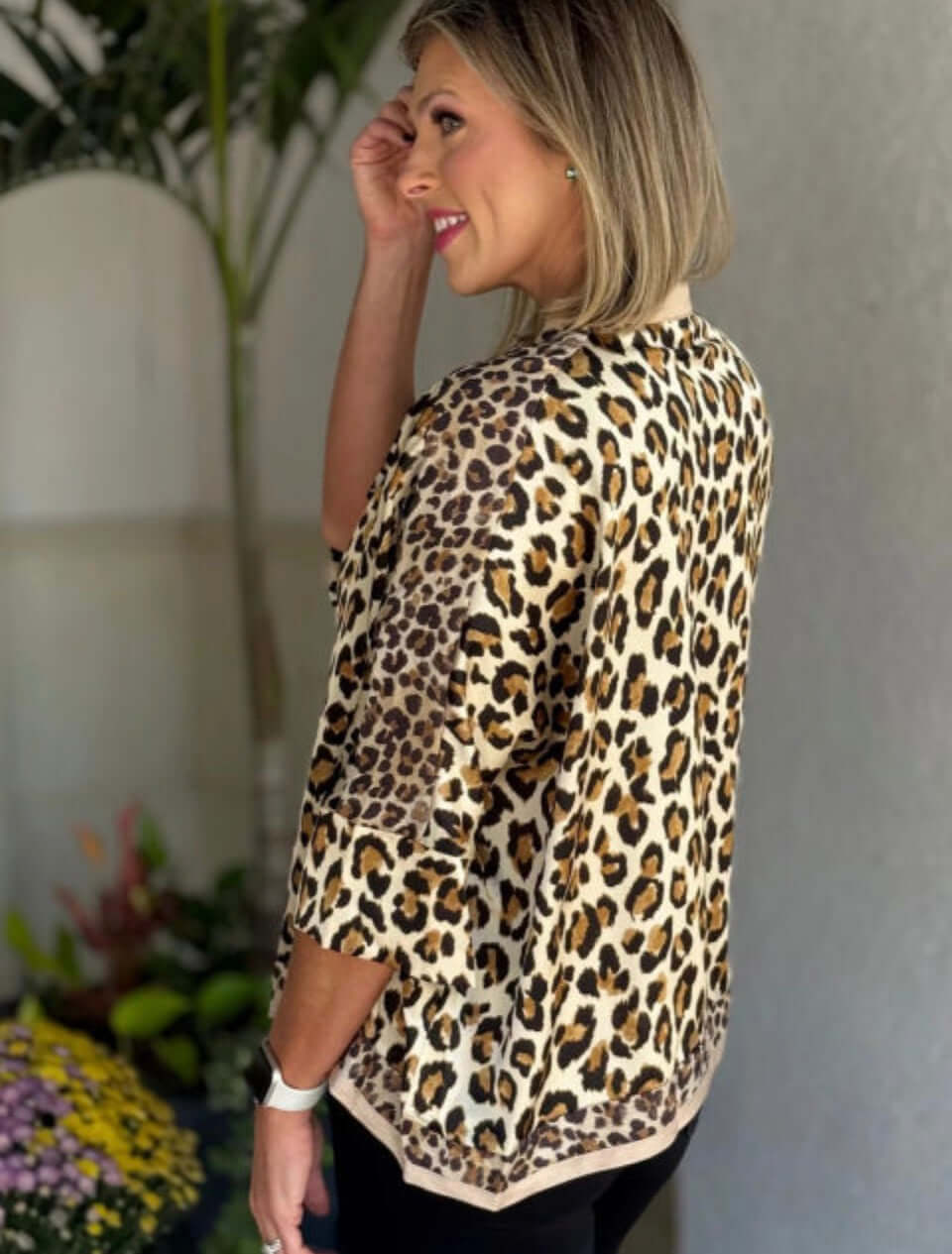Model showcasing the UNTAMED ELEGANCE top with leopard print design, perfect for a stylish and comfortable look.