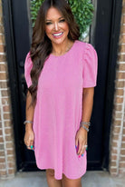 Smiling woman in rose pink Carefree Spirit Dress with puff sleeves, showcasing a casual and stylish look.