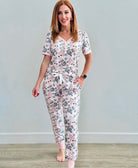 Woman wearing Shirley & Stone Mirror Ball Snowman PJ Set with Christmas trees and snowmen on soft pink fabric.