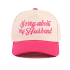 SORRY ABOUT MY HUSBAND HAT (6 colors) featuring pink embroidery on a cream trucker hat with a pink bill.