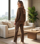 Woman wearing SPOT ON COZY SET with leopard print in a modern living room setting.