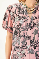 Close-up of the Love To Be Me Dress featuring a floral print on a soft pink background and stylish puff sleeves.