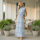 BLUE WILLOW BREEZE DRESS - Jodifl worn by a smiling model on a porch, featuring a soft blue botanical print and pockets.