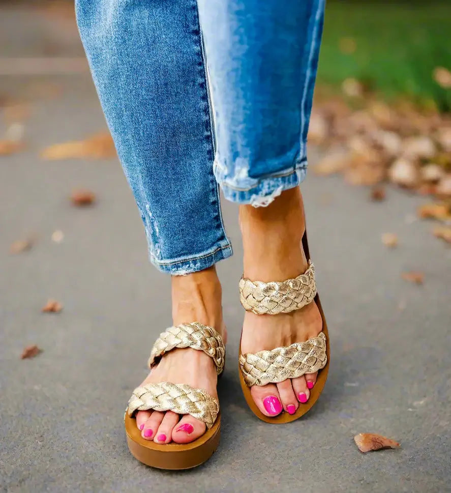 Corkys Wind It Up gold sandals with braided straps, styled with denim jeans and bright pink pedicure.