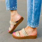 Stylish Corkys Wind It Up gold braided sandals paired with blue jeans for a trendy summer look.