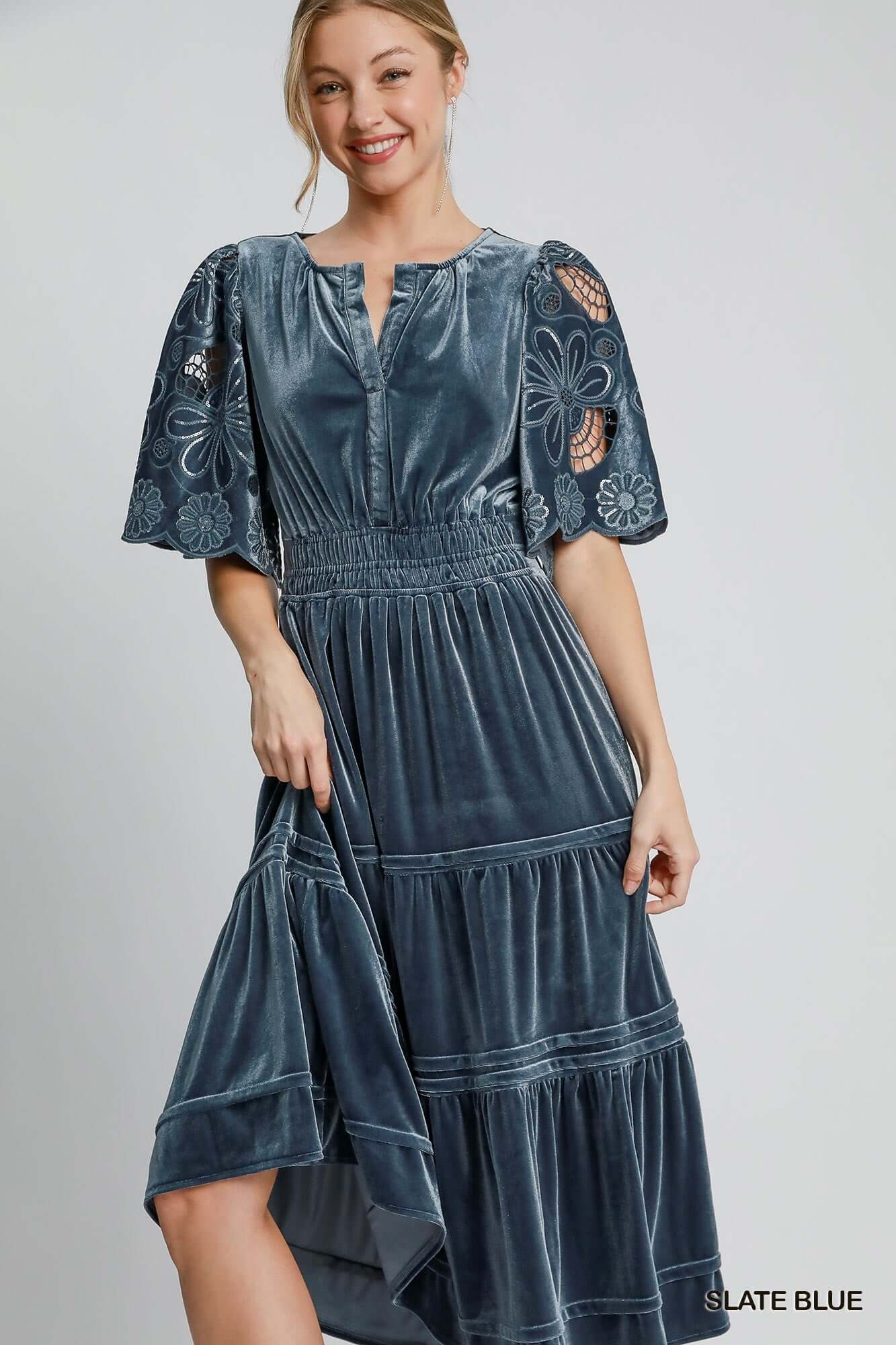 Woman wearing a slate blue PURE HAPPINESS Dress by Umgee with floral lace flutter sleeves and velvet fabric.