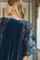 Woman wearing BRIGHT SPIRITS blue velvet top with floral embroidered flutter sleeves and pleated back by Umgee